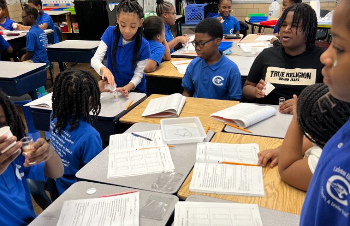  Students working on their science reaction project when water and oil are mixed together. 